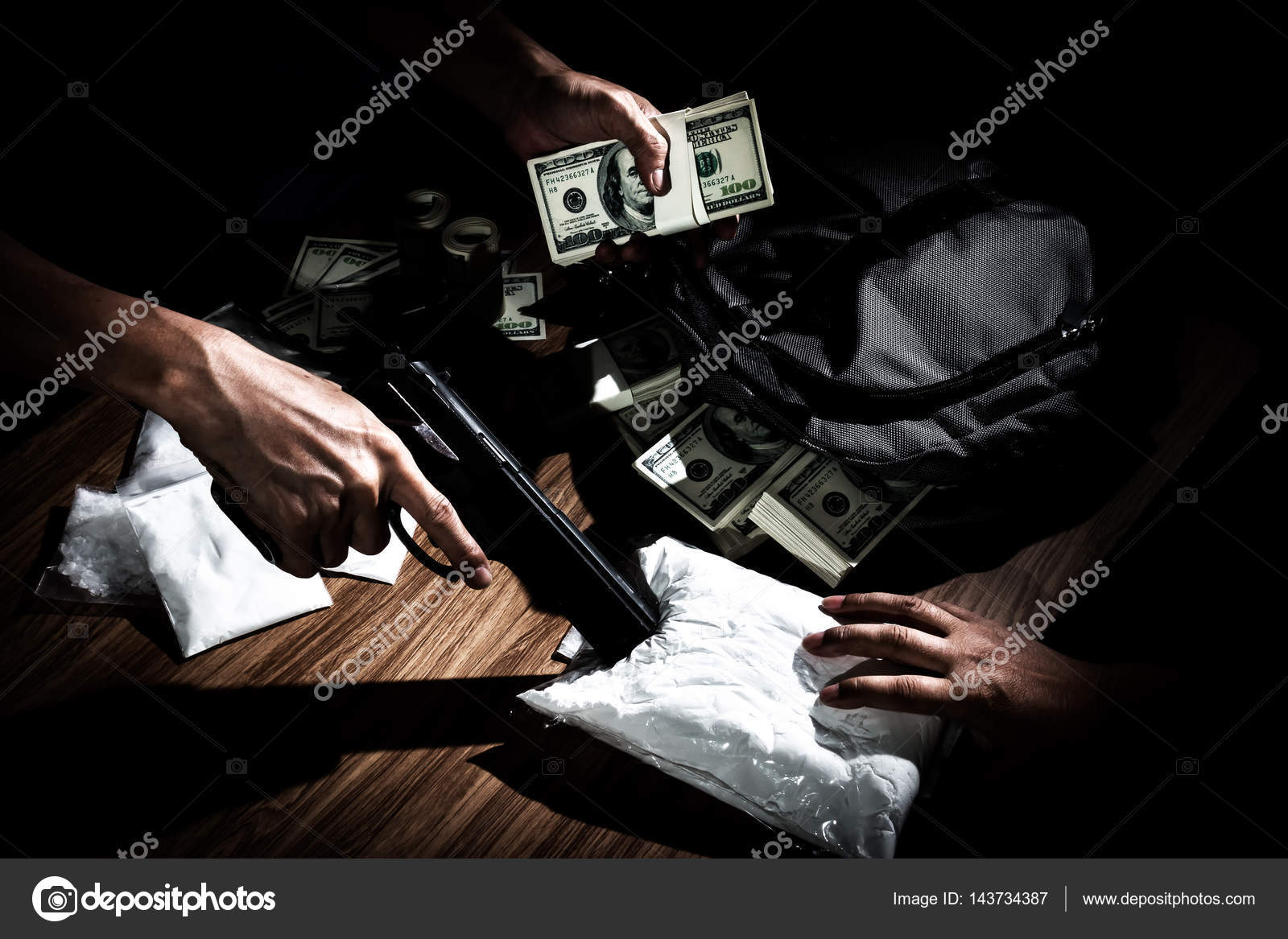 Drug dealer use gun to push the envelope on the table to buyer Stock