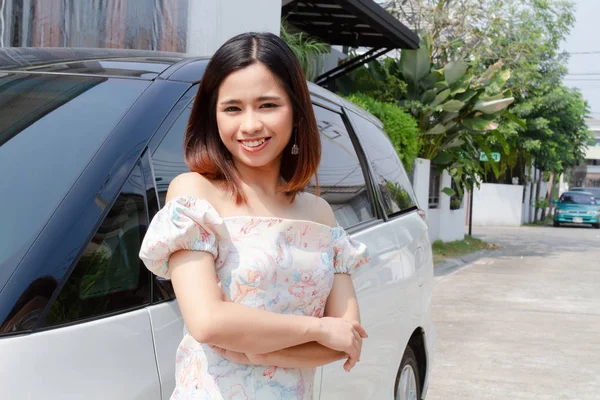 Jovem mulher de pé perto de carro novo na rua — Fotografia de Stock