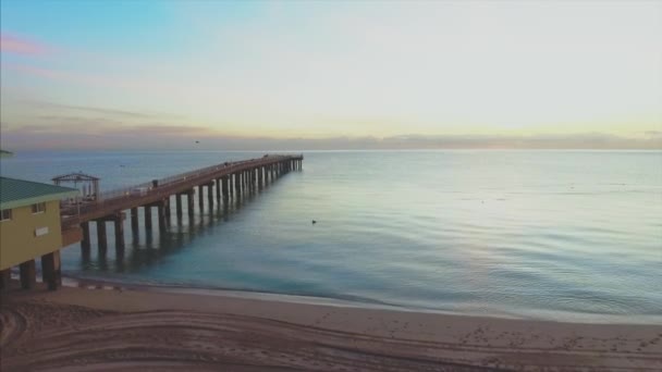 Luchtfoto tilt omhoog van pier gebied in strand in Florida tijdens zonsopgang — Stockvideo