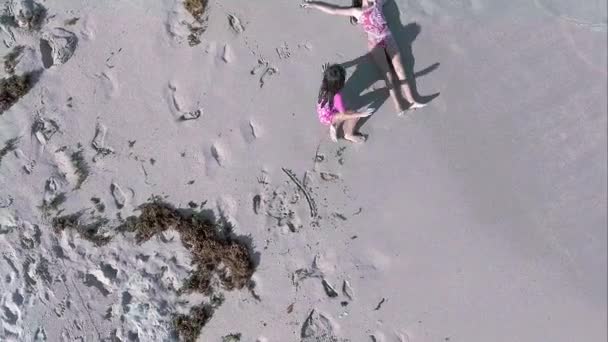 Cool plan aérien de deux filles allongées dans le sable sur la plage au bord de l'océan, prise de vue de jour .