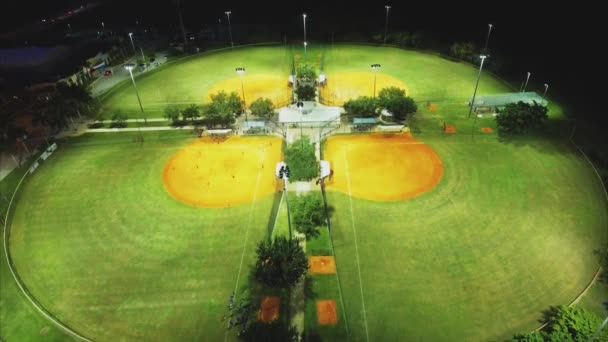 Повітряний постріл літає над бейсбольними парками ввечері — стокове відео