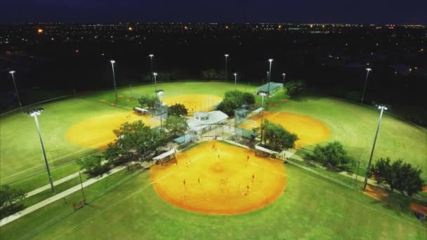 Raffreddare colpo aereo sorvolando parchi di baseball la sera durante la partita — Video Stock