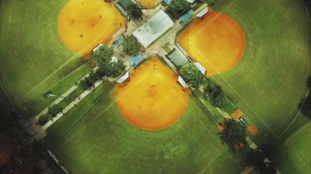 Disparo aéreo acercándose a los campos de béisbol por la noche — Vídeo de stock