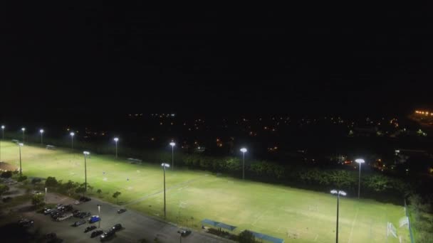 都市の真ん中にサッカー場の空中夜ショット — ストック動画