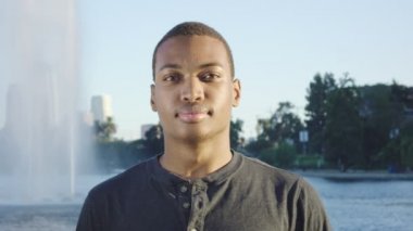 Afrikalı Amerikalı genç adam kameraya bakıyor.
