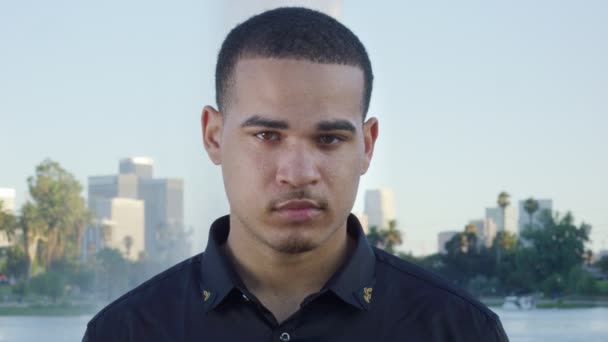 Young man looking at camera in front of park in Los Angeles — Stock Video