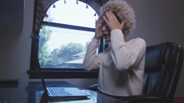 Mujer transgénero actuando molesta por algo que está leyendo en su computadora portátil — Vídeo de stock