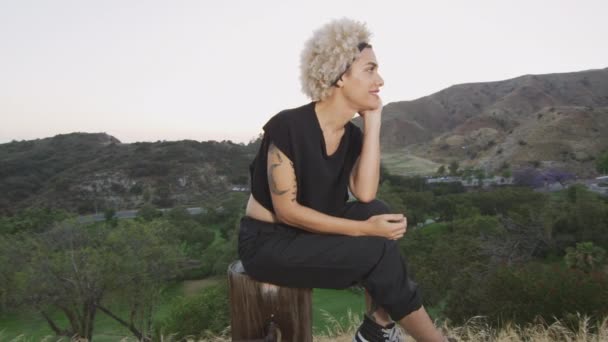 Happy transgender woman sitting in front of beautiful view — Stock Video