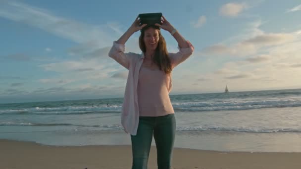 Vrouw neemt Vr bril af en kijkt naar de oceaan — Stockvideo