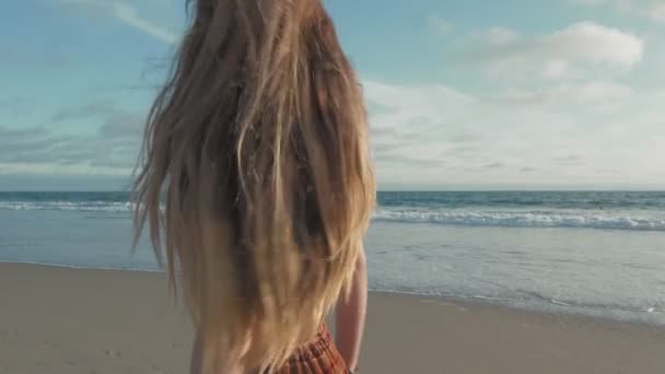 Jonge vrouw met lang haar wandelen op het strand — Stockvideo