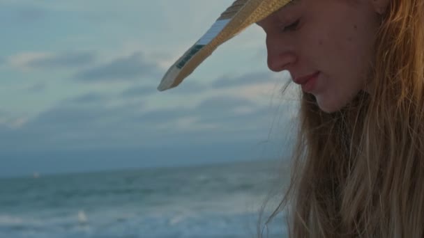 Młoda kobieta na plaży używa telefonu komórkowego nad oceanem. — Wideo stockowe