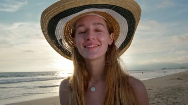 Jeune femme branchée à la plage souriant à la caméra — Video