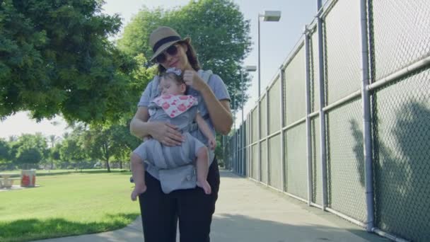 Mãe acariciando seu bebê adormecido em um parque — Vídeo de Stock
