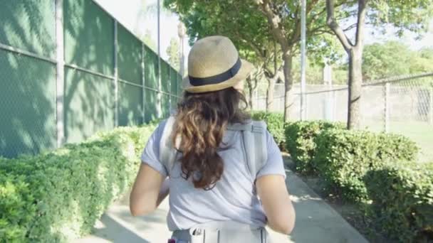 Mulher com bebê em transportadora andando em um parque — Vídeo de Stock