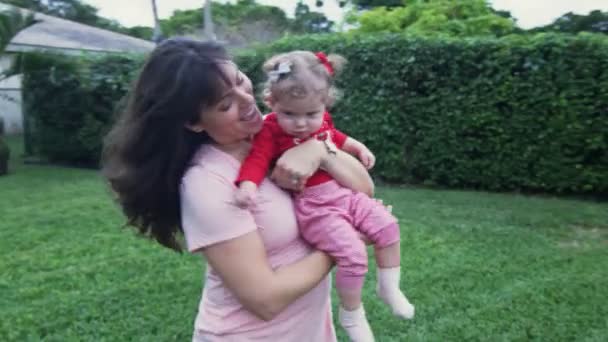 Mother holding baby daughter with Christmas outfit outside — Stock Video