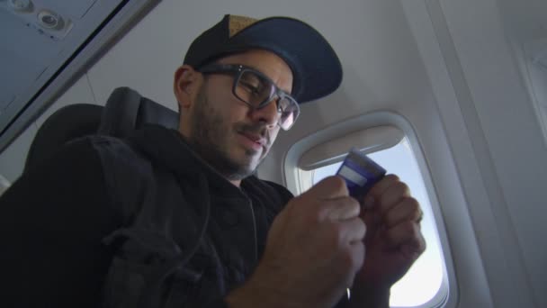 Uomo su un aereo guardando la carta di credito — Video Stock