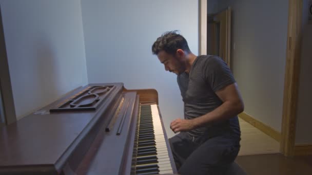 Uomo che entra e si siede per suonare il pianoforte — Video Stock