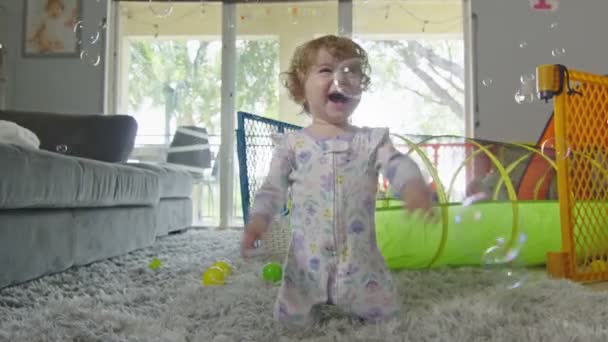 Mooi meisje spelen met bubbels thuis — Stockvideo