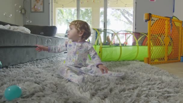 Movimento lento della bambina che gioca con le bolle a casa — Video Stock
