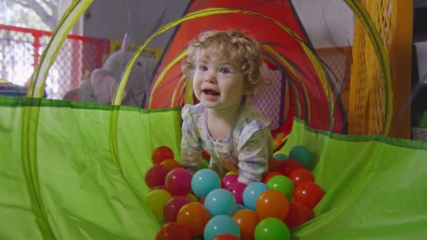 Movimento lento della bambina che striscia all'interno di un pozzo di palline — Video Stock