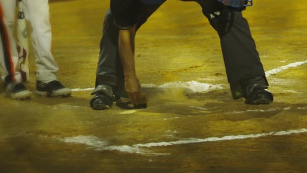 Cámara lenta del árbitro de béisbol limpiando la placa de casa — Vídeo de stock