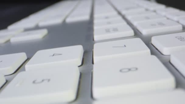 Macro disparo moviéndose a través de un teclado de computadora blanca — Vídeo de stock