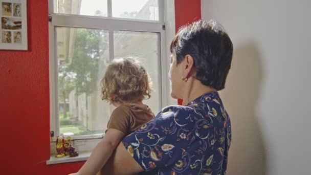 Grand-mère et bébé à la maison regardant par la fenêtre — Video