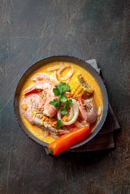 Peruvian seafood soup Chupe de Camarones in gray bowl, top view clipart