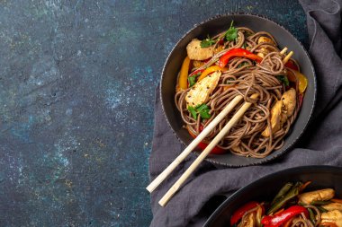Japon karabuğdaylı soba şehriyesi tavuk ve sebzeli havuç, dolma biber ve yeşil fasulye gri kasede, üst manzara, kopyalama alanı
