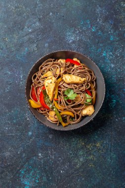 Japon karabuğdaylı soba şehriyesi tavuk ve sebzeli havuç, dolma biber ve yeşil fasulye gri kasede, üst manzara, kopyalama alanı