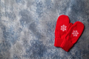 Noel ve yeni yıl kompozisyonu atkıyla, kadın eldiveni ile, sıcak içecekle bardaklar ve gri beton arka planda lokum. Düz yatış, üst görünüm.