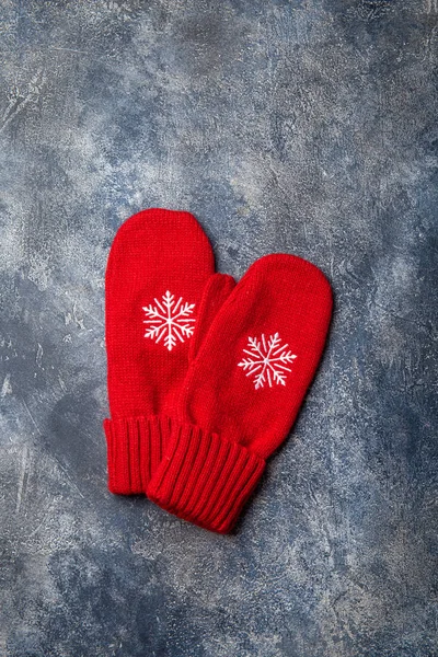 Noel ve yeni yıl kompozisyonu atkıyla, kadın eldiveni ile, sıcak içecekle bardaklar ve gri beton arka planda lokum. Düz yatış, üst görünüm.