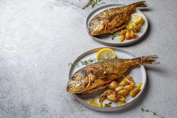 Izgara deniz çerezi ya da gri tabakta dorada. Gri arkaplan
