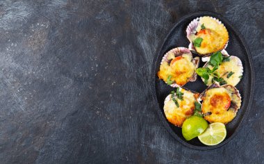 Peynirli ve limonlu fırında deniz ürünleri. siyah arkaplan.