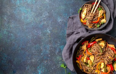 Japon karabuğdaylı soba şehriyesi tavuk ve sebzeli havuç, dolma biber ve yeşil fasulye gri kasede, üst manzara, kopyalama alanı