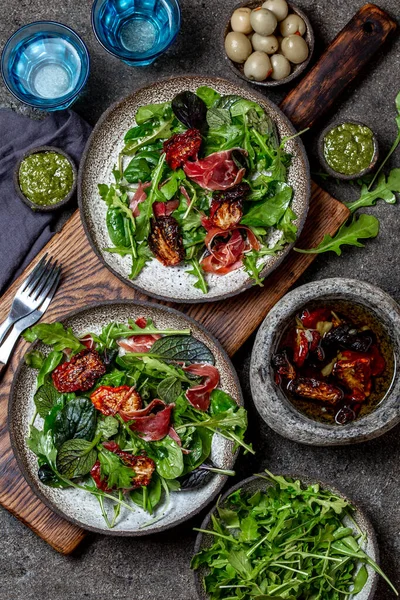 Salada com arugula, espinafre, tomate seco e presunto serrano paleta iberica. Receita keto de carboidratos baixos — Fotografia de Stock