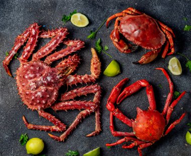 Siyah arkaplanda yengeç seçimi olan deniz ürünleri arka planı.