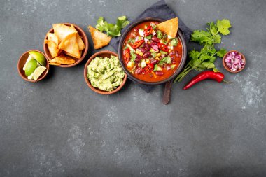 Meksika siyah fasulye çorbası, domates, avokado ve totopos. Gri arkaplan, üst görünüm.