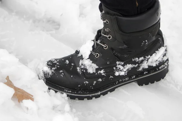 O pé humano no sapato está na superfície da neve — Fotografia de Stock