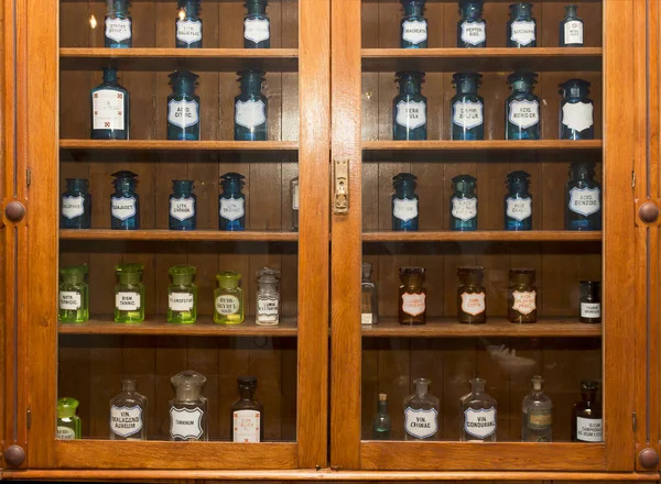 Um conjunto de utensílios antigos com diferentes medicamentos em uma vitrine em uma farmácia — Fotografia de Stock