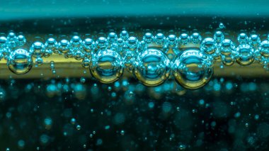 arka plan, sıvı yüzeydeki hava toplarının dokusu, soğuk sarı ve mavi renklerde, makro çekim