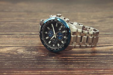 Tahta masada erkek bileği metal saati.