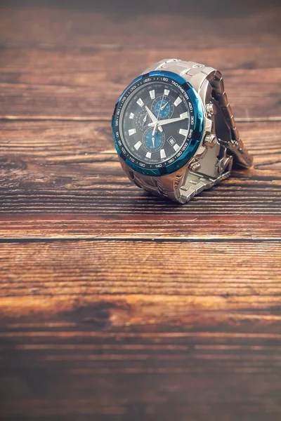 木製テーブルの上の男性の手首の金属腕時計 — ストック写真