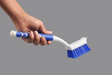 İnsan eli temizleme için plastik fırça tutuyor.