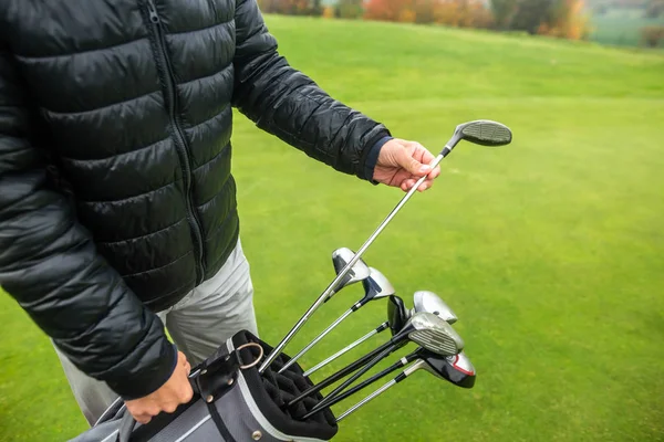 Profesyonel golfçü çantasından golf sopasını seçiyor.