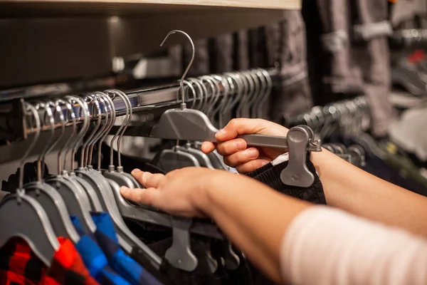 Mujer joven eligiendo la ropa en el enorme centro comercial durante las grandes ventas, concepto de finanzas — Foto de Stock