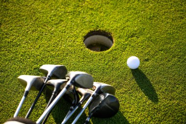 Güzel, temiz bir çimenlikte profesyonel golf ekipmanları, biraz top ve iki golf sopası, spor konsepti.