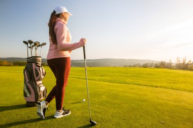 Profesyonel kadın golfçü golf sahasında yarışmaya hazır.
