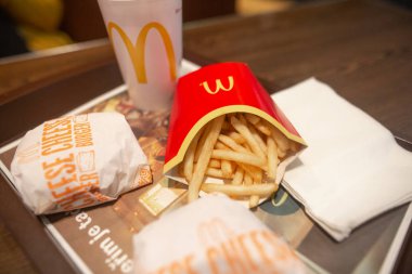 McDonald menu with french fries, hamburger and cola on a plate in McDonalds restaurant clipart