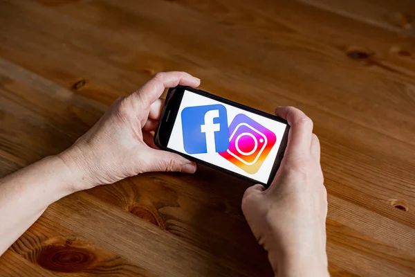 Facebook i Instagram logo znak ekran aplikacji na telefon komórkowy online detalicznej usługi, ręce na — Zdjęcie stockowe